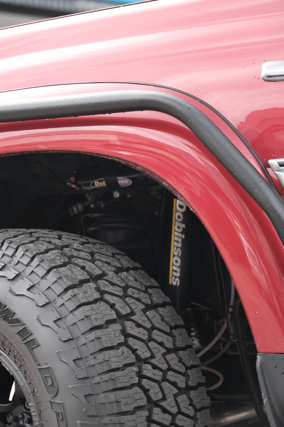 Black wheel and mud terrain tyre under the flared arch