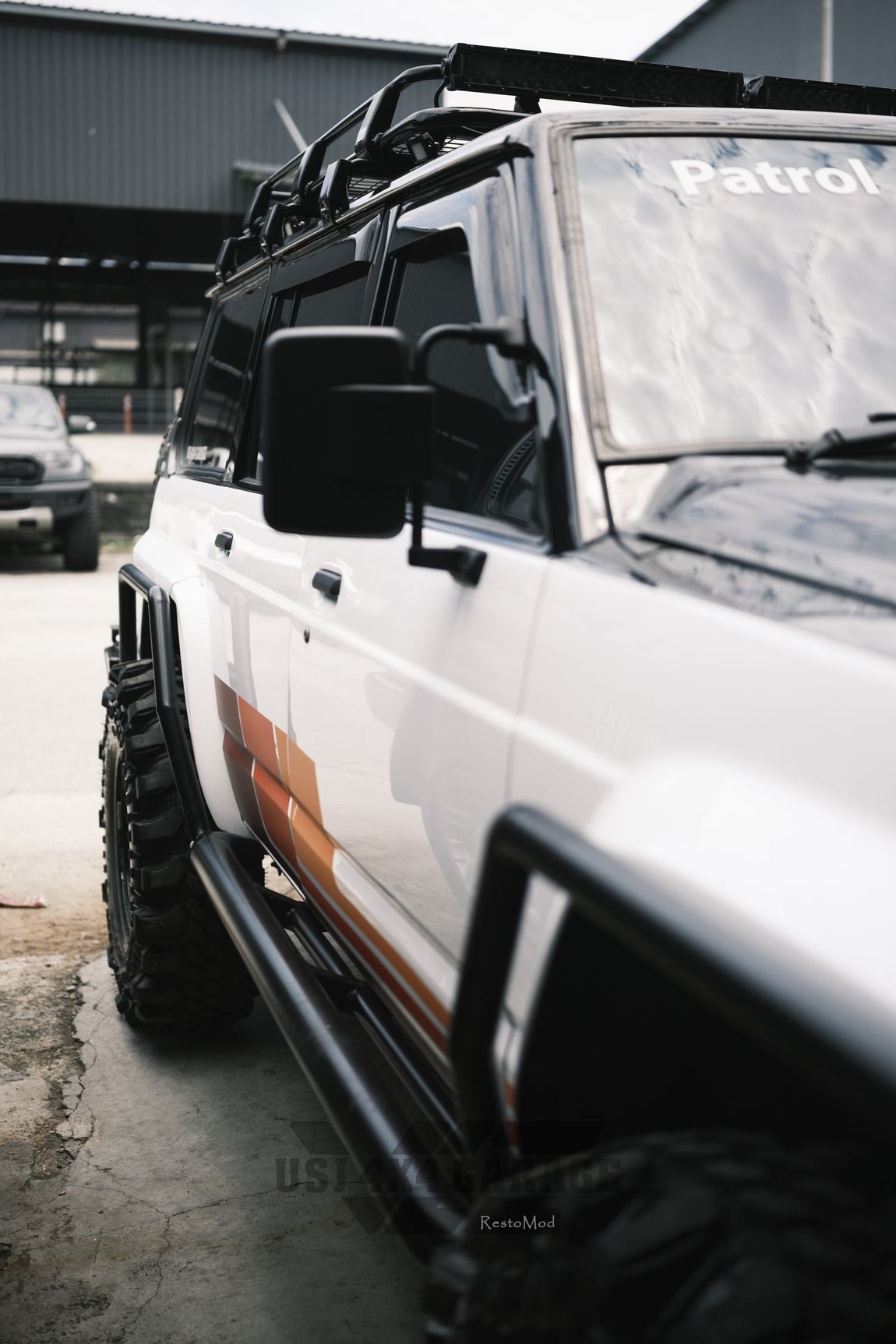 Nissan Patrol side profile with rock sliders and mud terrains