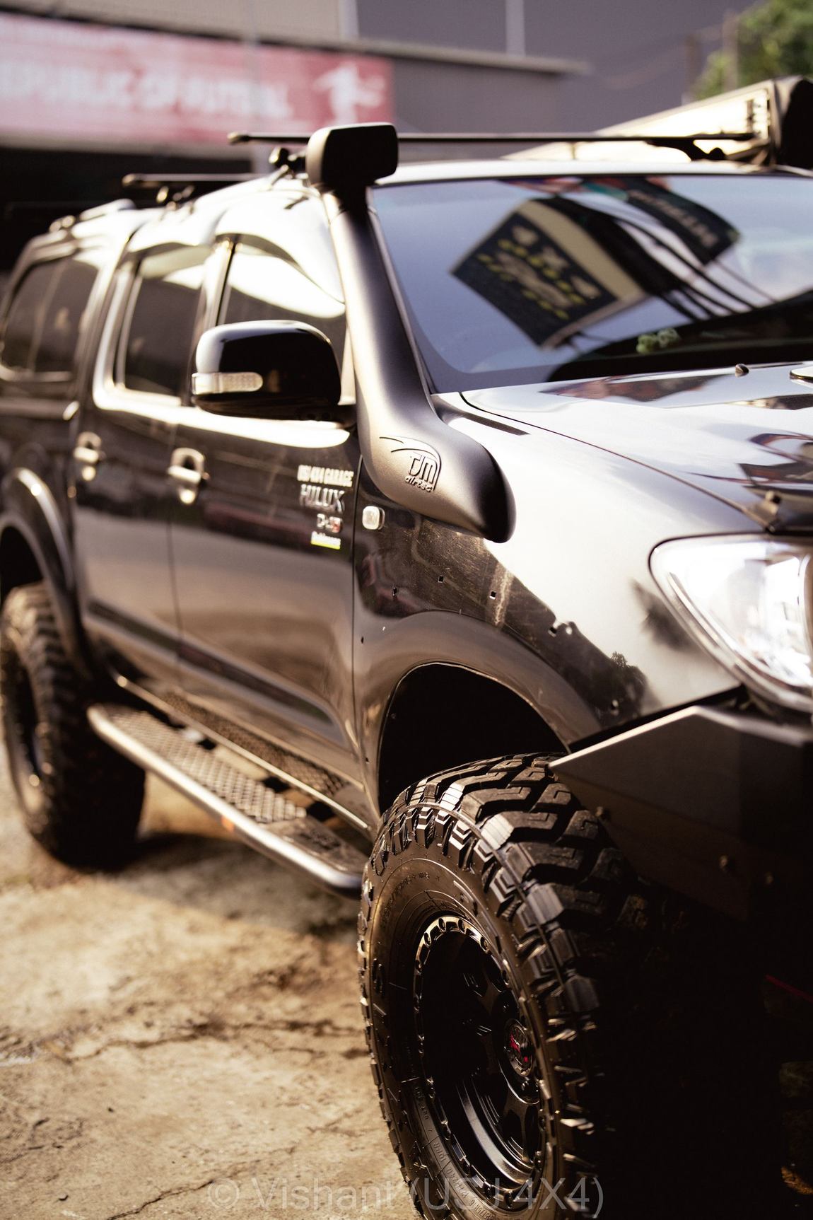 Low front three-quarter of the black Hilux Vigo